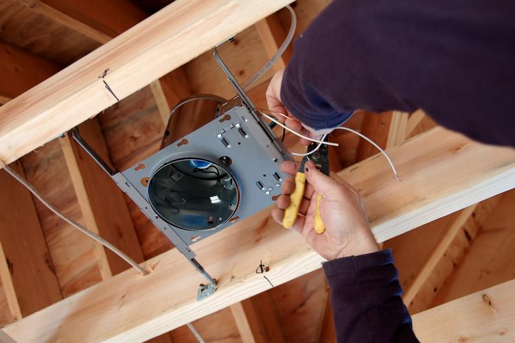 Man installing light and wiring